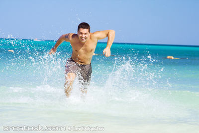 tanned man running out of the ocean