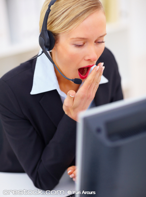 Beautiful tired blond receptionist yawning whi...