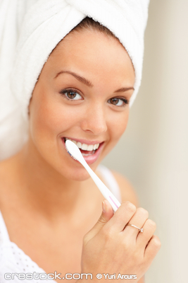 Smiling young woman with healthy teeth holding...