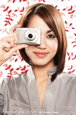 Beautiful smiling young woman holding a digita...