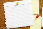 torn notebook page on cork board
