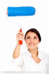 woman painting a wall in front of her with blu...